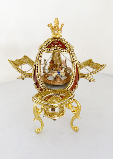 Open door view of jewelled egg with interior mini carousel