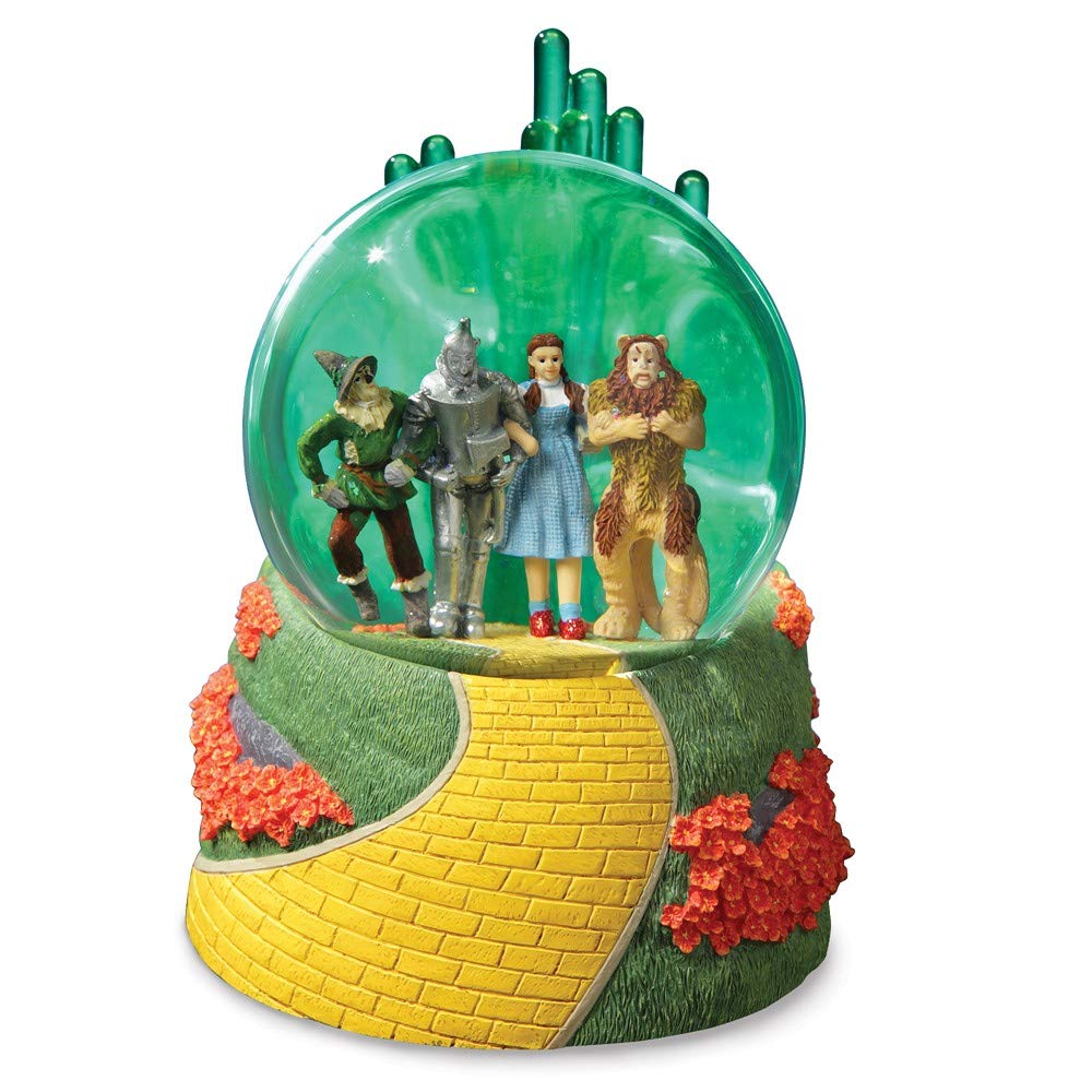 Four friends in water globe on the yellow brick road with glowing Emerald City in the background.