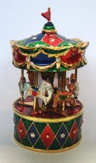 Miniature revolving musical carousel on red and green base