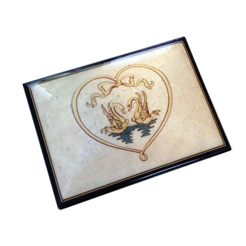 White music box featuring two swans framed with heart shaped ribbon