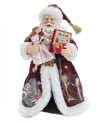 Santa dressed in rich fabric holding Clara and her Nutcracker.