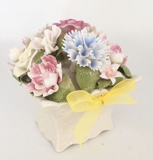 White musical planter with soft colored flowers